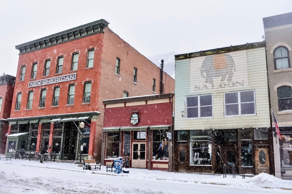 Snow falls over Telluride’s historic New Sheridan Hotel and neighboring saloon, blending old-town charm with winter quiet.