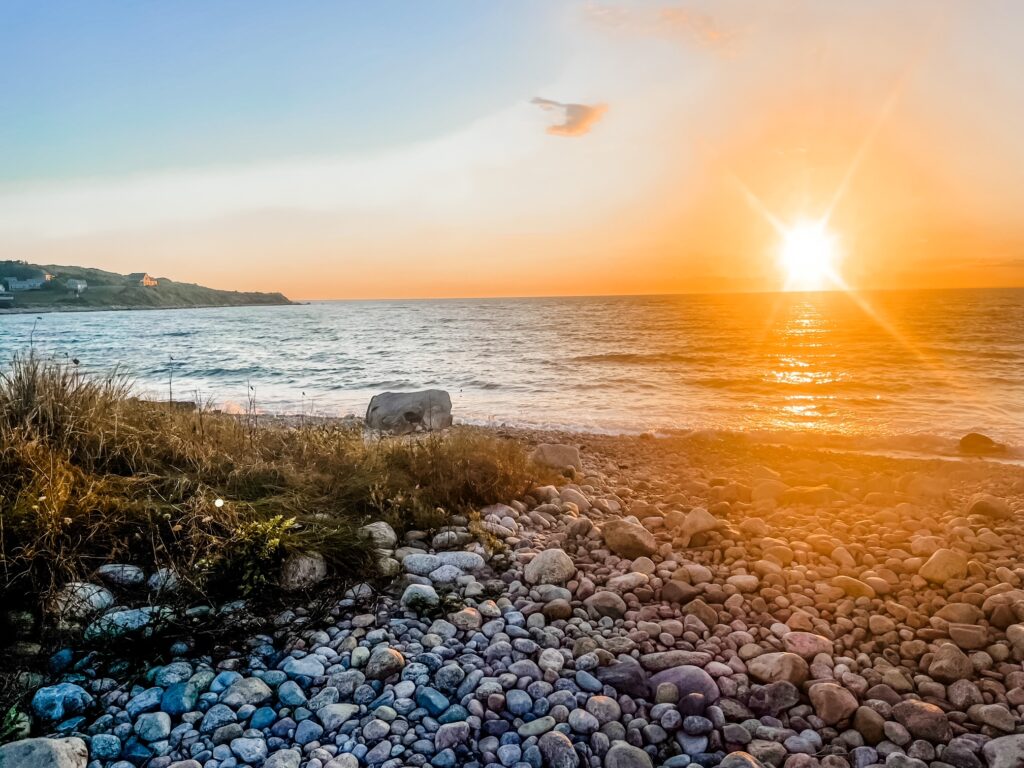 Golden hour sunset over a rocky shore at Churches Beach on Cuttyhunk Island