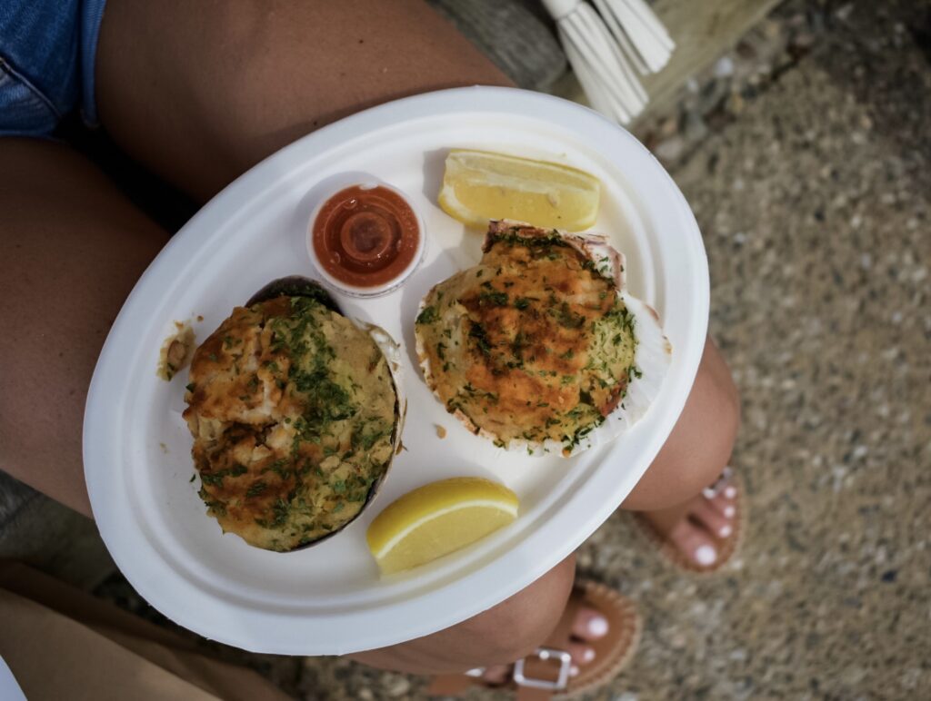 A plate of baked stuffed clams (stuffies) served with lemon wedges and hot sauce.