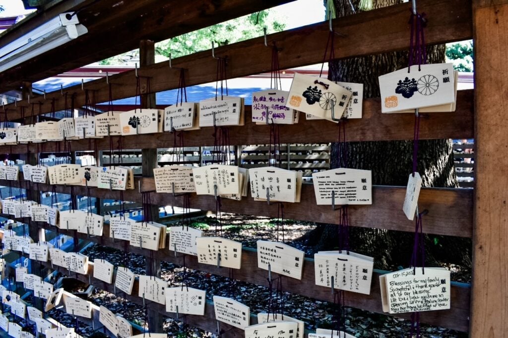 Rows of wooden plaques with handwritten wishes hanging at the shrine.