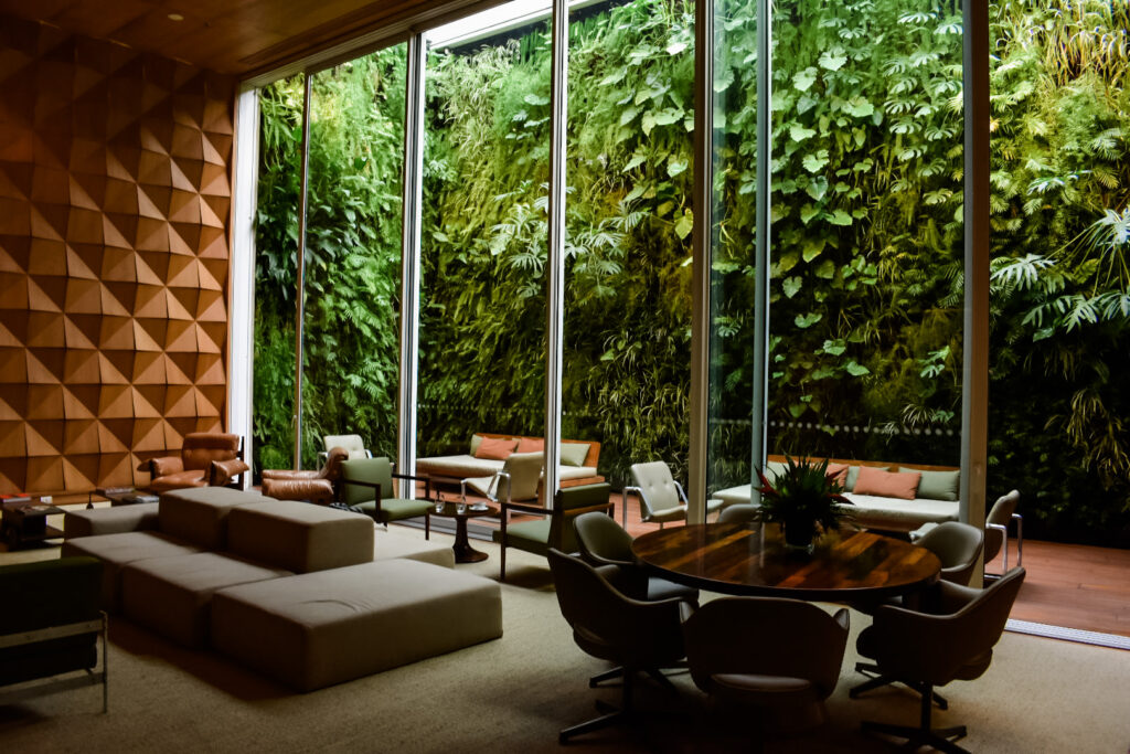Modern lounge at Hotel Emiliano with natural light and a lush green living wall.