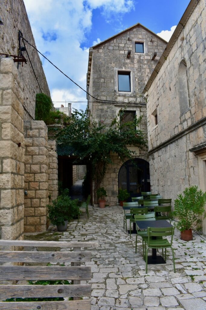 A tucked away cafe in Korcula, Croatia surrounded by cobblestone streets and historic buildings