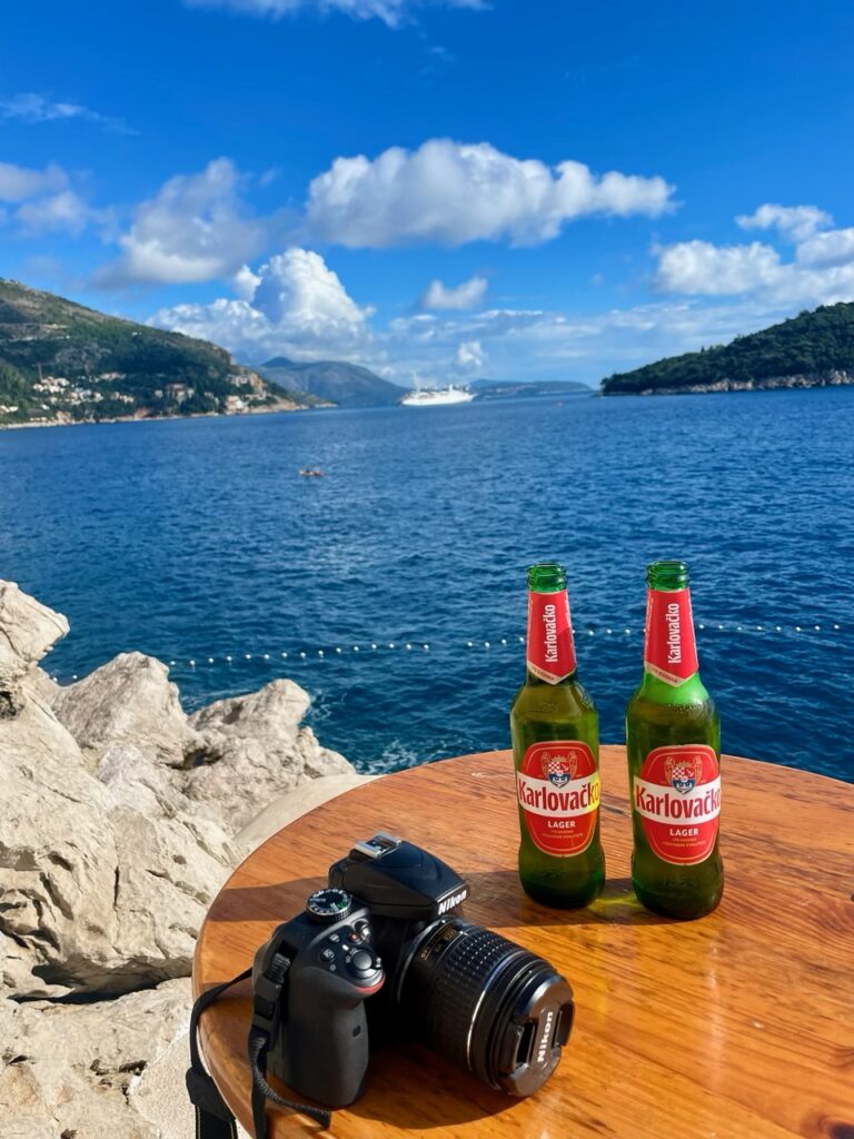 Local Korčula beers at Buza Bar overlooking the Adriatic Sea, with ocean views and rocky cliffs in Dubrovnik, Croatia