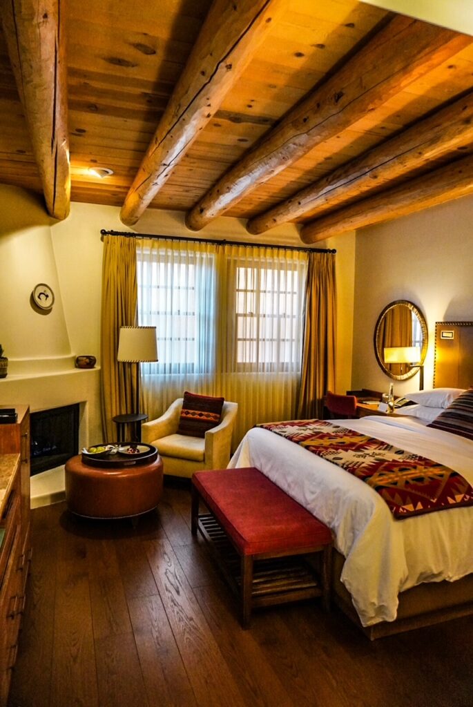 Cozy Southwestern-style hotel room with warm wood beams and woven textiles.