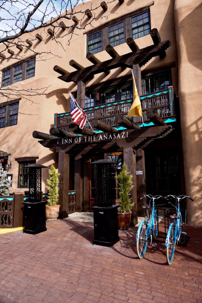 Adobe-style exterior of the Inn of the Anasazi with turquoise bikes by the entrance.