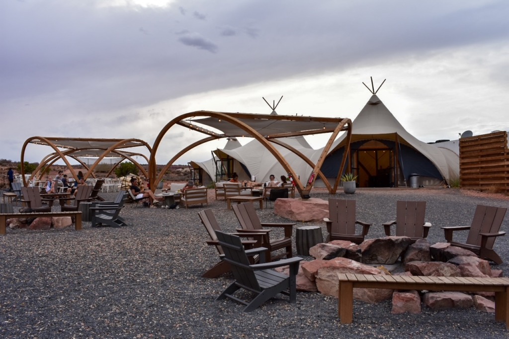 Outdoor lounge area with firepits and modern tent structures at Under Canvas Lake Powell glamping site