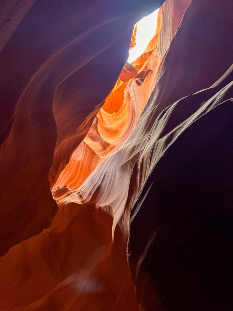 Light beam highlighting vibrant orange and red sandstone formations inside Antelope Canyon, Arizona