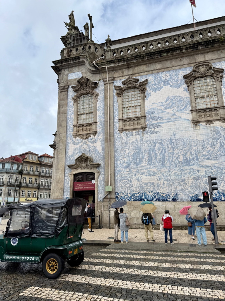 The blue and white azulejo tile exterior of Capela das Almas church in Porto, Portugal, with detailed figurative scenes covering the entire facade on Rua de Santa Catarina